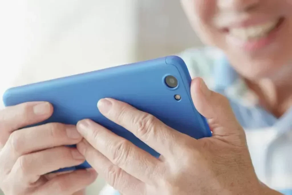 Uma mulher com um celular na mão.