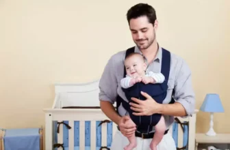 Um homem segurando um bebê com um canguru.