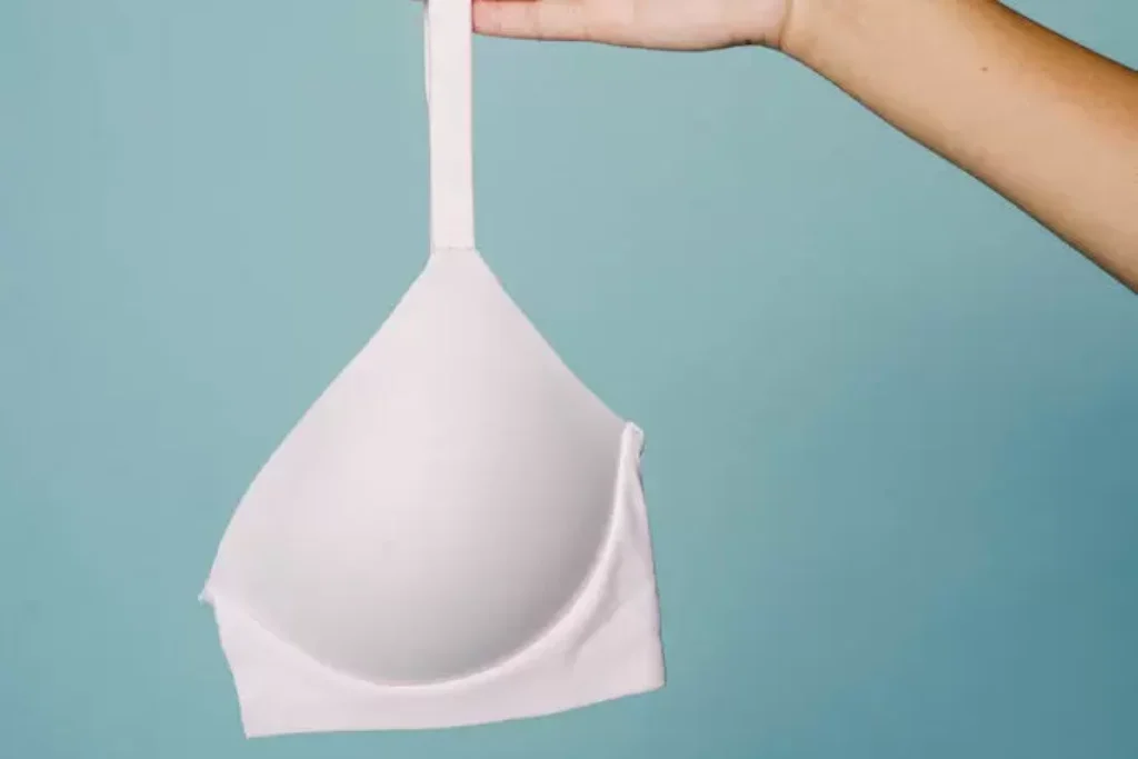 Uma mulher segurando um sutiã.