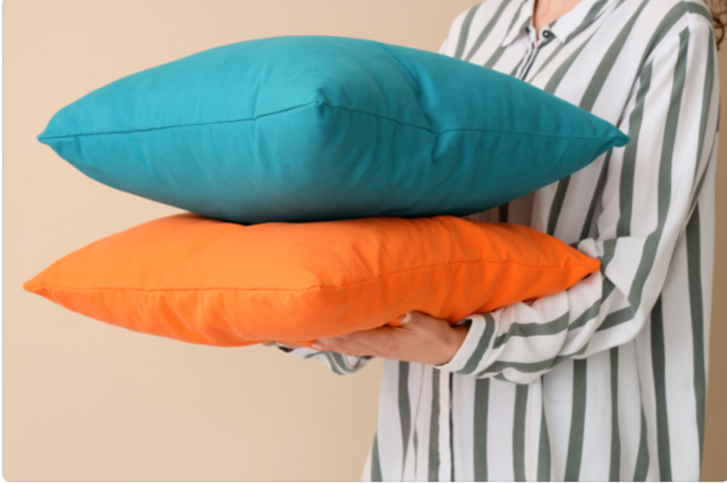 Dois travesseiros na mão de alguém