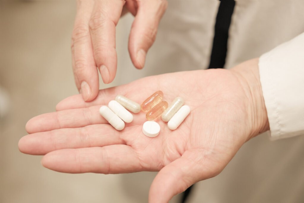 Pessoa com comprimido nas mãos.
