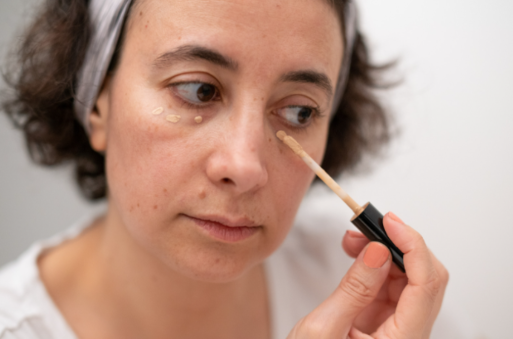 Mulher usando corretivo nas olheiras 