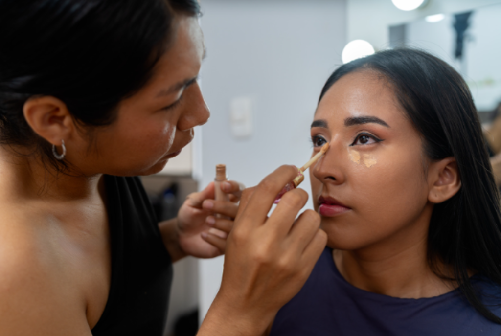 maquiadora passando corretivo na cliente 