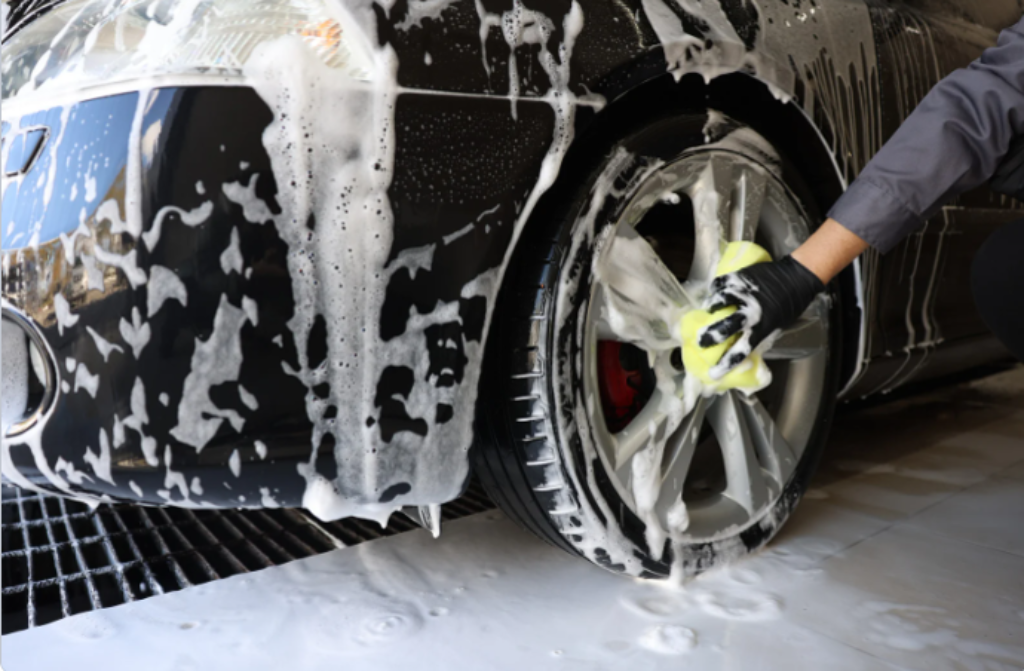 carro sendo lavado por alguém